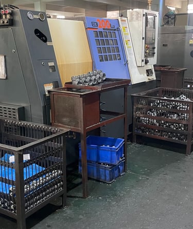 Industrial CNC lathe machines in a factory workshop producing precision metal components and parts.