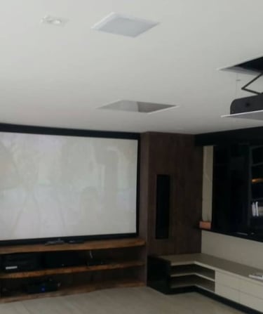 Telão e projetor de video embutido em sala ampla