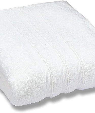 Soft white cotton bath towel folded neatly, showing plush texture and ribbed decorative border.