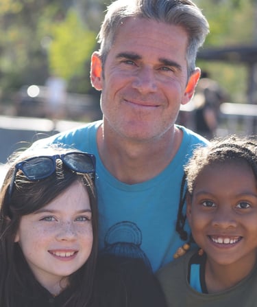 a man with two young girls smiling