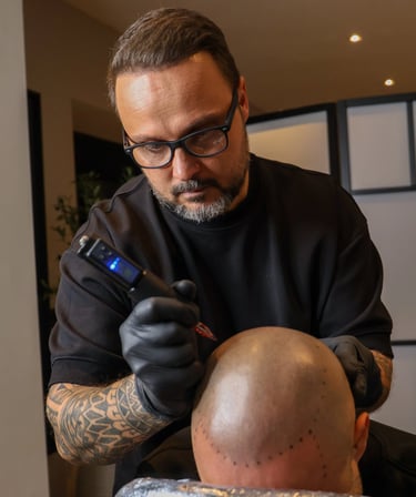 expert en micropigmentation capillaire qui réalise la tricoigmentation sur un homme