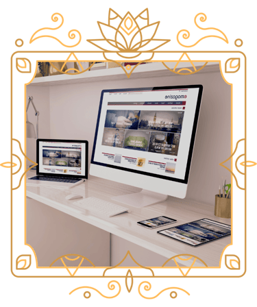 two computers, a phone and an iPad on a desk in a victorian frame