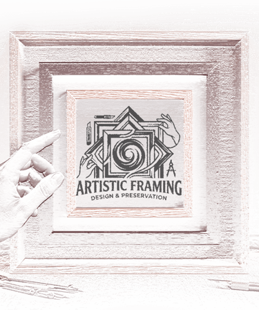 Custom wooden frame displaying the Artistic Framing Design & Preservation logo with drafting tools.