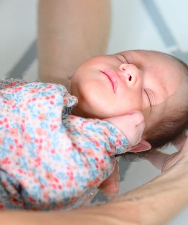 Bébé emmaillotté dans une couverture, très paisible pendant le Bain des Merveilles