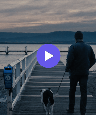 man and dog walking towards a jetty