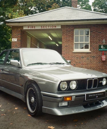 a classic BMW parked in front of a brick building