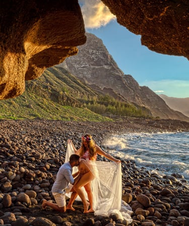 a man and woman standing on a rocky beach