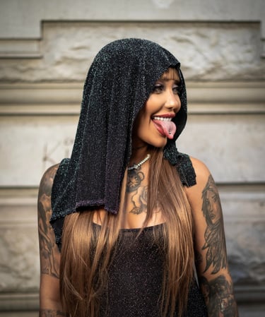 Model in black hooded outfit posing for street fashion shoot by Fred Art Studio.