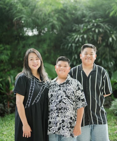 siblings standing together in a relaxed portrait during a family photography session at Movenpick Jimbaran Bali