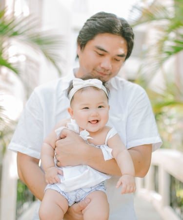 Father holding baby in tropical garden during family photography session at Sofitel Nusa Dua Bali