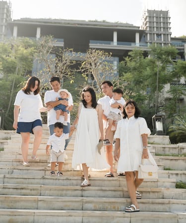 Large family walking down the iconic staircase at The Apurva Kempinski Nusa Dua Bali during a family photography session