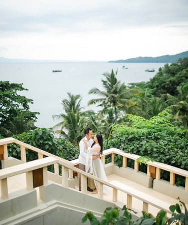 Elegant prewedding couple at Amankila Karangasem standing on ocean view stairs in East Bali