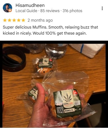 A hand holding a 50mg THC cannabis infused muffin in clear plastic packaging.