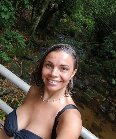 a woman in a black dress standing on a bridge