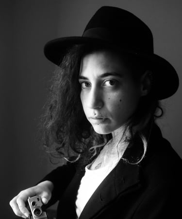 a woman photographe with a hat posing for a photo