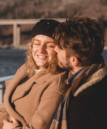 dečko i cura sjede na klupi u zagrljaju