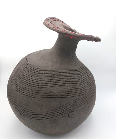 Estelle Del artiste sculpture représentant un pot en terre noire en  déséquilibre