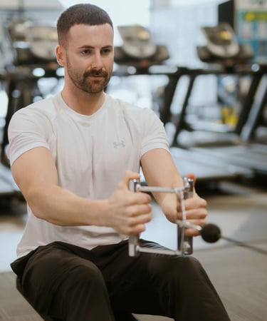 Person performing weighted row in Leamington Spa gym, focused on strength and back activation