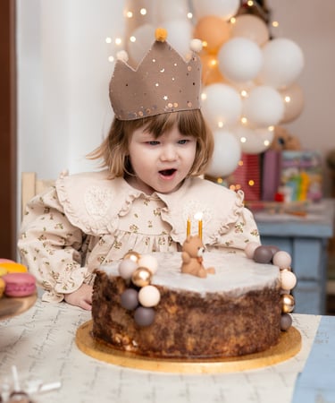 mala djevojčica koja puše svijeće na torti
