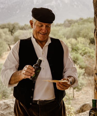 Man in traditional dress pouring olive oil on pane carasau, Sardinia