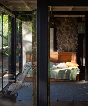 living room with a couch and lots of windows on a beautiful stone wall