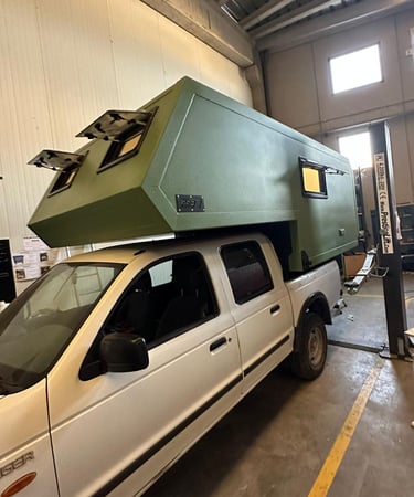 un vehículo pick up verde con cabina camper