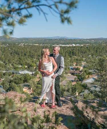 a man and woman standing on a mountain top