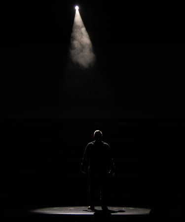 a man standing in front of a spotlight light