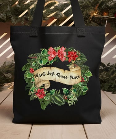 Black tote with poinsettia wreath and “Plant Joy. Share Peace” — botanical holiday bag by Miss Chatty Plants
