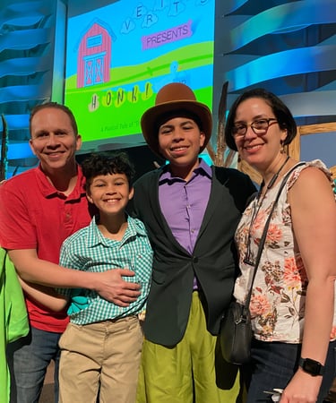 a family posing for a picture in front of a screen