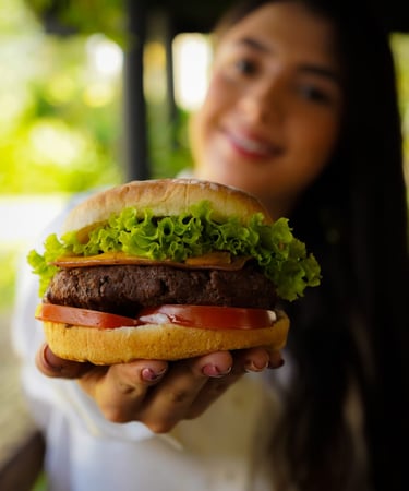 joven disfrutando de una Hamburguesa Artesanal con  200 gr  de carne Angus en Beer and Burger