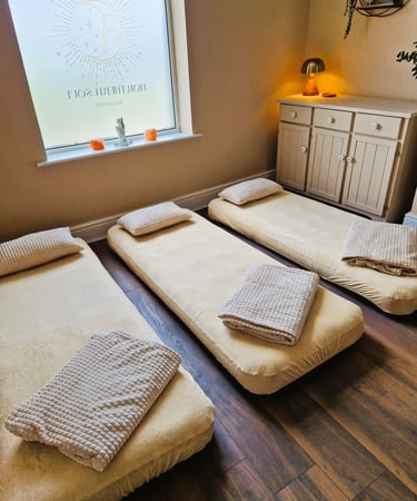 Three air beds on the floor with blankets and pillows