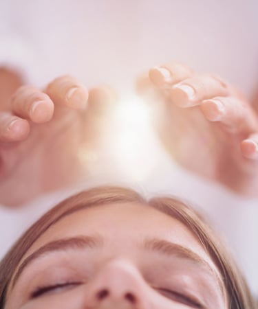 Hands projecting light hovering above a head