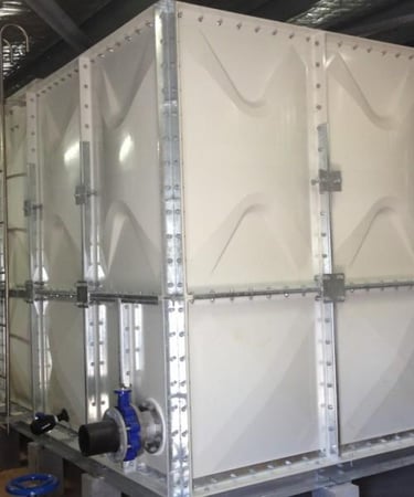 GRP panel water tank installation with galvanized steel frame, ladder access, and piping connections