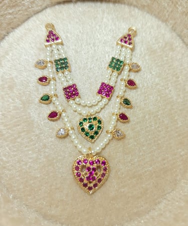 a necklace with a heart shaped pendant and a pearl necklace