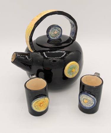 a teapot with a teapot and cups, moon, sun finial, ceremony