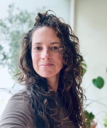 a woman with long hair and a brown sweater