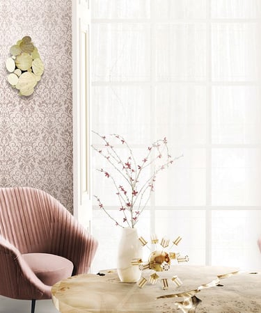 Elegant living room featuring pink damask wallpaper, velvet armchairs, and luxury gold wall sconces.