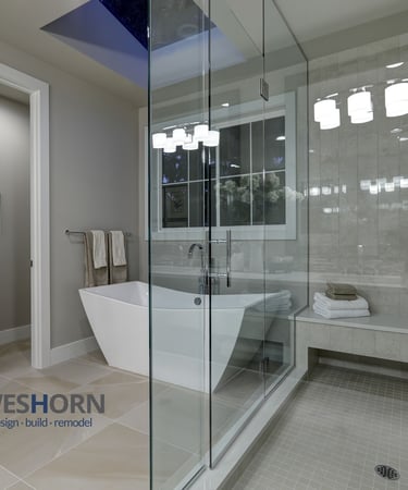 Modern luxury bathroom featuring a freestanding soaking tub and glass walk-in shower with stone tile.