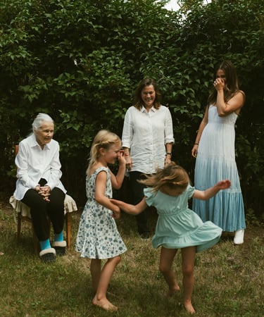 a family gathering in a backyard with a young girl playing with a frisbee