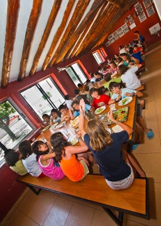 niños comiendo en el comedor del campamento