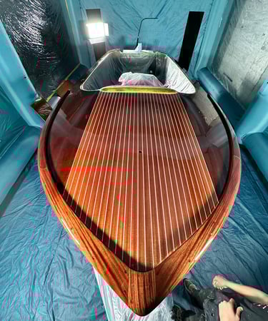 a man is painting a wooden boat in a boat