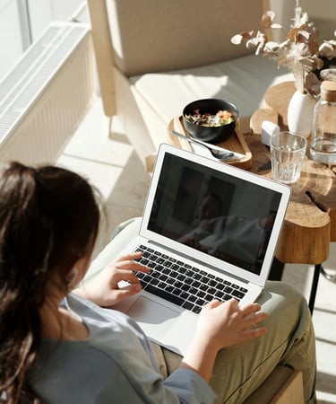 a woman sitting on a couch with a laptop