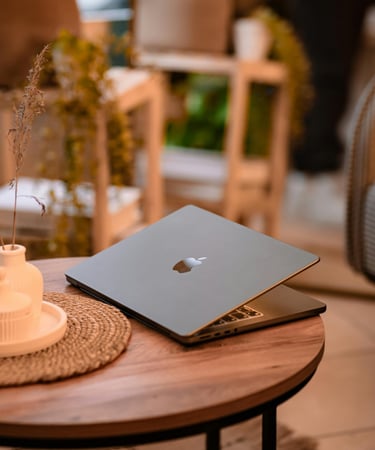 a laptop computer sitting on a table with a candle and a candlelight