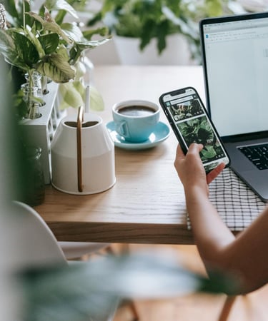 a person sitting at a table with a laptop and a cell phone