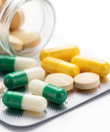 Close-up of pharmaceutical capsules being carefully inspected on a production line.