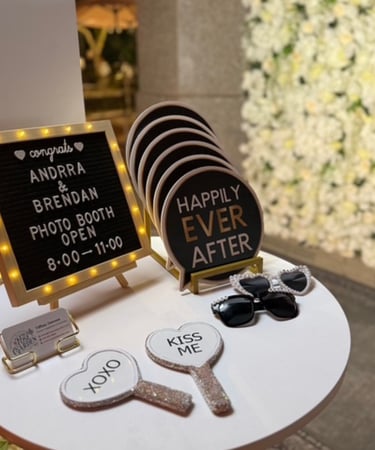 Wedding photo booth props with marquee letter board, heart-shaped signs, and party sunglasses.