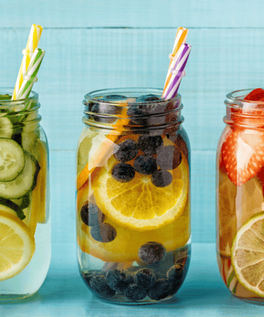 three jars of fruit and water with strawberries and lemonade