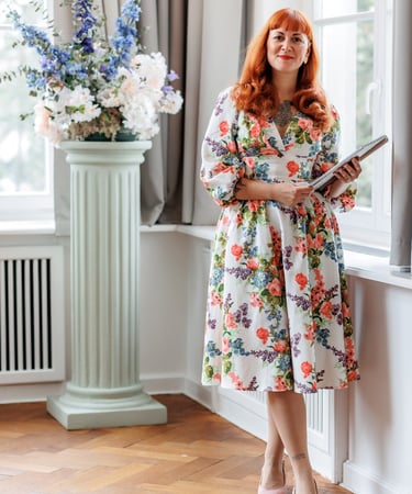 Ramona, freie Rednerin, steht im geblümten Outfit und Rede in den Händen bereit für die freie Trauung