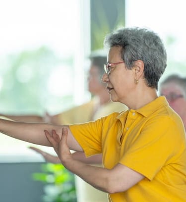 Practicing Tai Chi movements which helps promote wellness and healthy aging